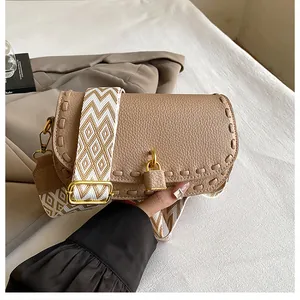 Détail du sac besace kaki avec cuir grainé et bandoulière tissée géométrique