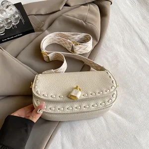 Sac à bandoulière en cuir beige avec sangle géométrique et cadenas doré élégant