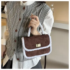 Macro detail of brown suede and white faux fur trim on a quilted mini crossbody bag