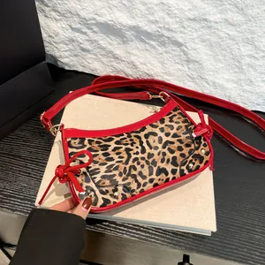 Chic leopard print handbag with red patent leather straps and side bow detail