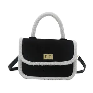Chic black quilted suede handbag with white faux shearling trim and gold clasp