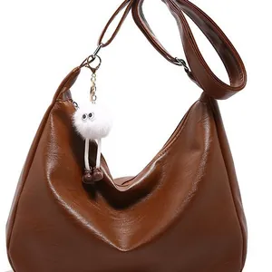 Sac hobo en cuir PU marron avec grande capacité et breloque en peluche sur fond blanc