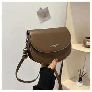 Détail d'un sac besace marron foncé en similicuir avec imprimé Fashion Trend EST 1996