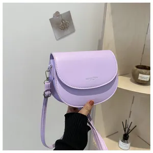 Détail du sac selle en similicuir lilas avec bandoulière réglable et boucle métallique