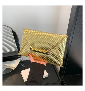 Dettaglio ravvicinato della pochette dorata con texture a pelle di serpente e fibbia in metallo