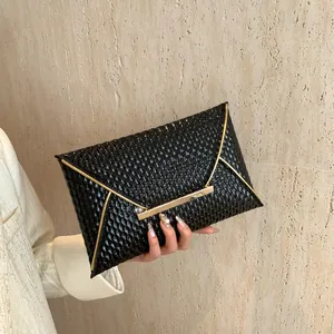 Elegante borsa a bustina nera con trama trapuntata lucida e cornice in metallo dorato