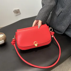 Minimalistische rote Unterarmtasche aus Leder mit goldener Schnalle und rundem Riemen
