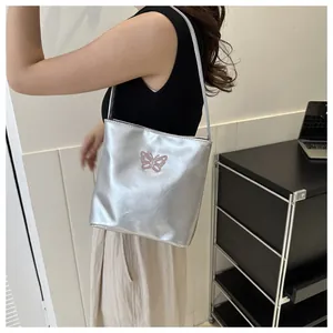 Silver metallic tote bag with pink butterfly embroidery and slender shoulder strap