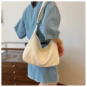 Detail of a creamy beige oversized hobo bag showing wrinkled faux leather and wide strap