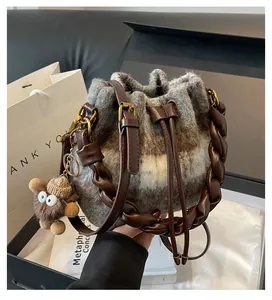 Détail du sac seau en laine avec cordon en cuir marron et pendentif monstre en peluche