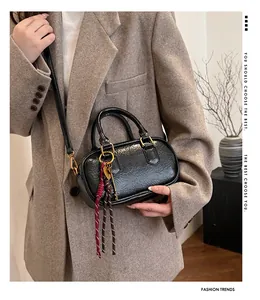 Détail d'un sac à main Boston noir texturé avec doubles poignées et un accessoire clé