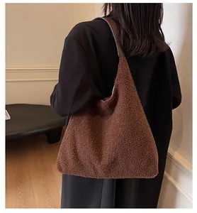 Detail der braunen Plüsch-Tote-Bag mit Lammwolltextur und dunklem Leder-Schulterriemen