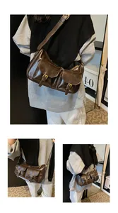 Dettaglio della borsa vintage marrone scuro con due tasche frontali e fibbie metalliche