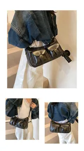Dettaglio borsa a tracolla vintage nera con doppie tasche anteriori e fibbia dorata