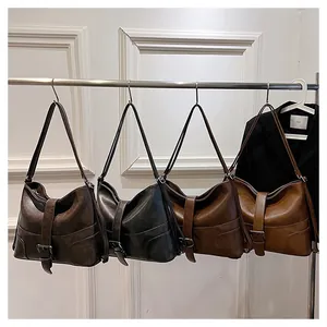Detail view of large vintage shoulder bags in four colors with strap buckle accents