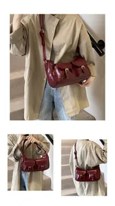 Dettaglio della borsa a tracolla vintage bordeaux con fibbie metalliche e tasche