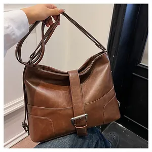 Close-up of vintage dark brown leather bag with metallic buckles and stitched details