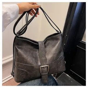 Close-up of vintage large capacity dark grey tote bag with buckle detail and matte leather texture