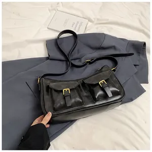 Dettaglio della borsa in pelle PU nera con doppie tasche e fibbie dorate vintage