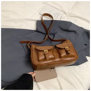 Dettaglio della borsa a tracolla marrone vintage con doppie tasche e misura del telefono