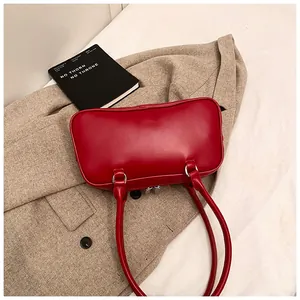 Detail of red leather shoulder bag featuring ballet-style bow and silver metal zipper