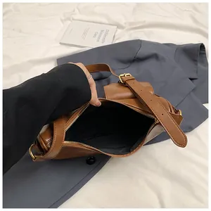 Dettaglio della capacità interna e della texture in pelle opaca marrone della borsa