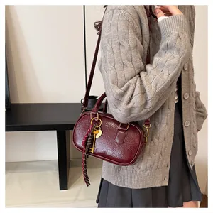 Détails du sac Boston bordeaux avec foulard rayé et pendentif clé dorée rétro