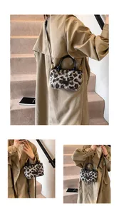 Detail of leopard print plush handbag with soft faux fur and black leather handles