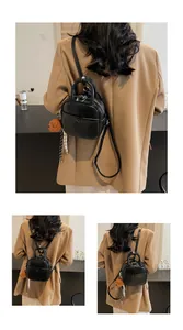 Détail du mini sac à dos en cuir noir avec breloque ours en peluche et sangle tissée