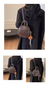 Détail du mini sac à dos en cuir PU marron avec un porte-clé décoratif en forme d'ours