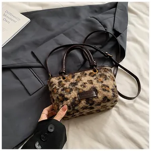 Close-up of leopard print faux fur texture and brand label on a stylish crossbody tote bag