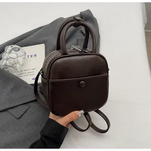 Détail du mini sac marron café avec double fermeture éclair et finition lisse