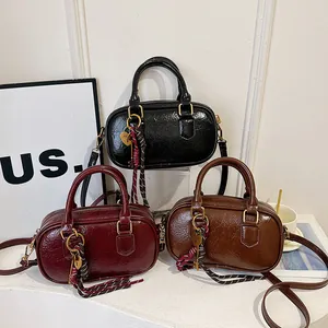 Trois sacs à main Boston élégants en noir, bordeaux et marron avec détails dorés