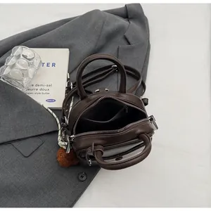 Vue détaillée de l'intérieur du sac marron avec fermeture éclair et pompon en peluche
