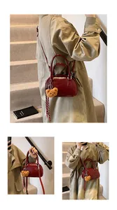 Detail of burgundy patent leather mini Boston bag with plush bear charm and ribbon