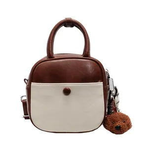 Sac bandoulière rétro marron et crème avec poignées et pendentif ours en peluche