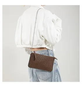 Detail of dark brown woven shoulder bag with silver ball chain trim and metallic strap