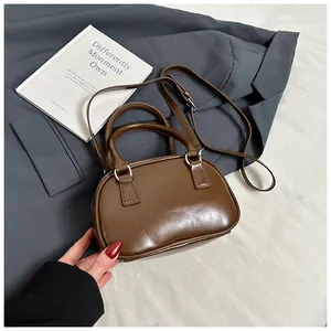 Detailed top view of a dark brown retro handbag on a suit jacket with prop book