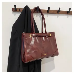 Detailansicht der dunkelroten Vintage-Einkaufstasche mit glänzendem Leder und Schnalle