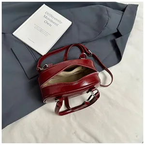 Top view of red patent leather crossbody bag with silver hardware and interior pocket