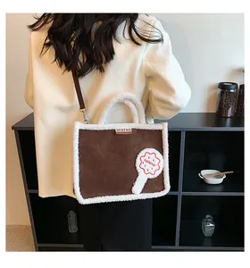 Detailansicht braune Wildlederoptik-Tasche mit weißem Lammfellbesatz und Keks-Applikation