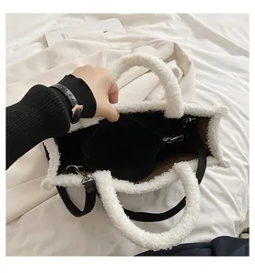 Detailansicht einer weißen Plüschtasche mit schwarzem Innenfutter und Reißverschluss