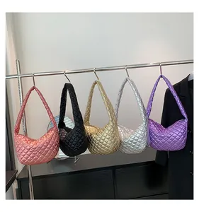 Rack of quilted metallic dumpling bags in pink, black, gold, silver, and purple