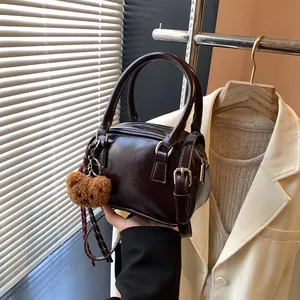 Retro dark brown Boston bag with glossy leather finish and cute plush bear charm