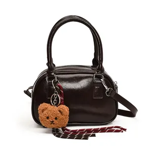 Vintage dark brown Boston handbag in glossy patent leather with a plush bear charm