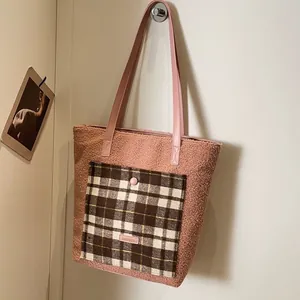 Pink sherpa tote bag with plaid pocket and leather straps for winter commute style
