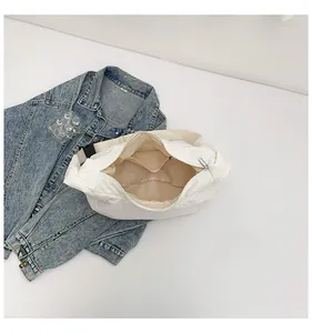 Vue détaillée du sac croissant blanc matelassé avec poche intérieure et fermeture