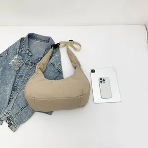 Sac lune en nylon matelassé beige avec bandoulière réglable et accessoires variés