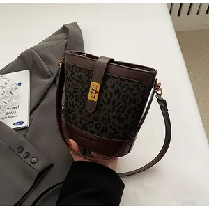 Détail du sac seau vintage avec imprimé léopard, boucle dorée et bandoulière en cuir