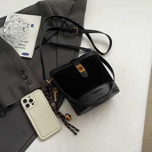 Sac seau à motif léopard avec fermoir doré et breloques sur un blazer élégant